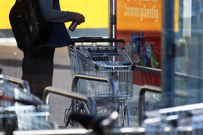 Zákazník pri nákupnom vozíku pred supermarketom v Berlíne; zdroj: Krisztian Bocsi/Bloomberg