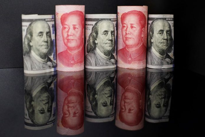 Na ilustračnej snímke z 29. septembra 2022 sú bankovky čínskeho jüanu a amerického dolára. REUTERS/Florence Lo/Ilustračné foto